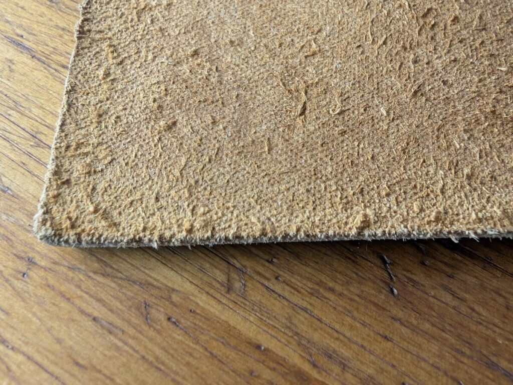 Close-up of the suede-like underside of the Wanderings leather cover showing its fibrous texture.